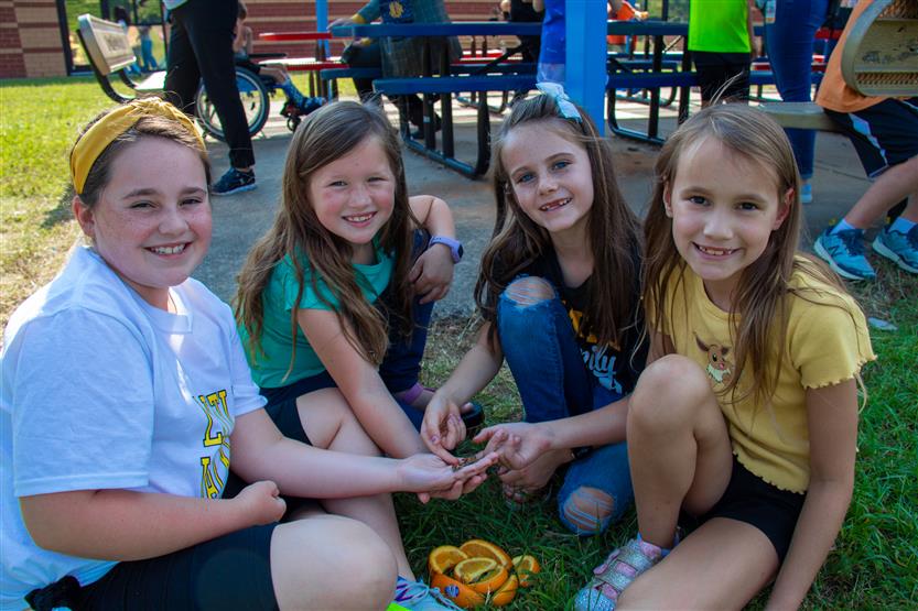 Four students hold a butterfly